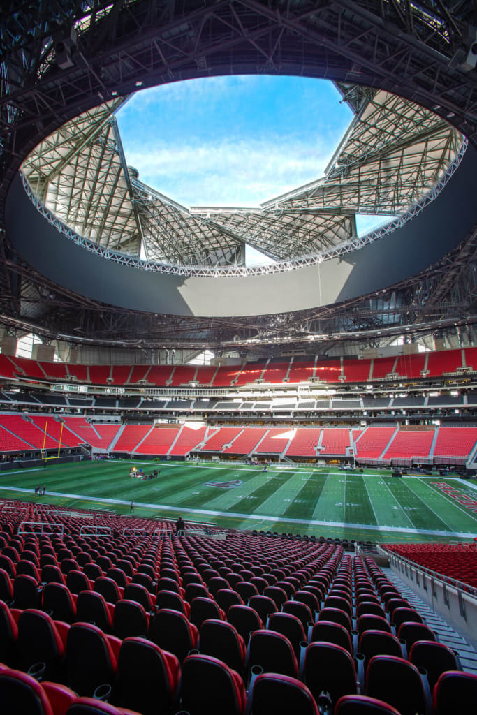 A modern stadium with a distinctive curved roof and red seating, ready for a sporting event in Atlanta, Georgia.