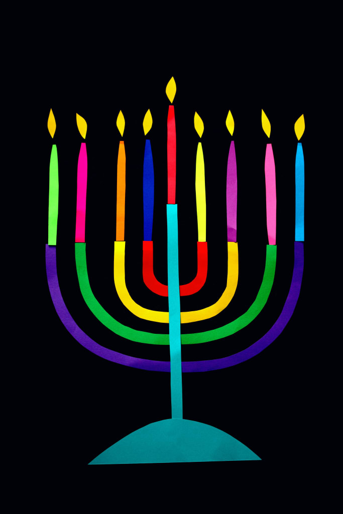 A stylized menorah with nine colorful candles on a black background in Atlanta, Georgia.