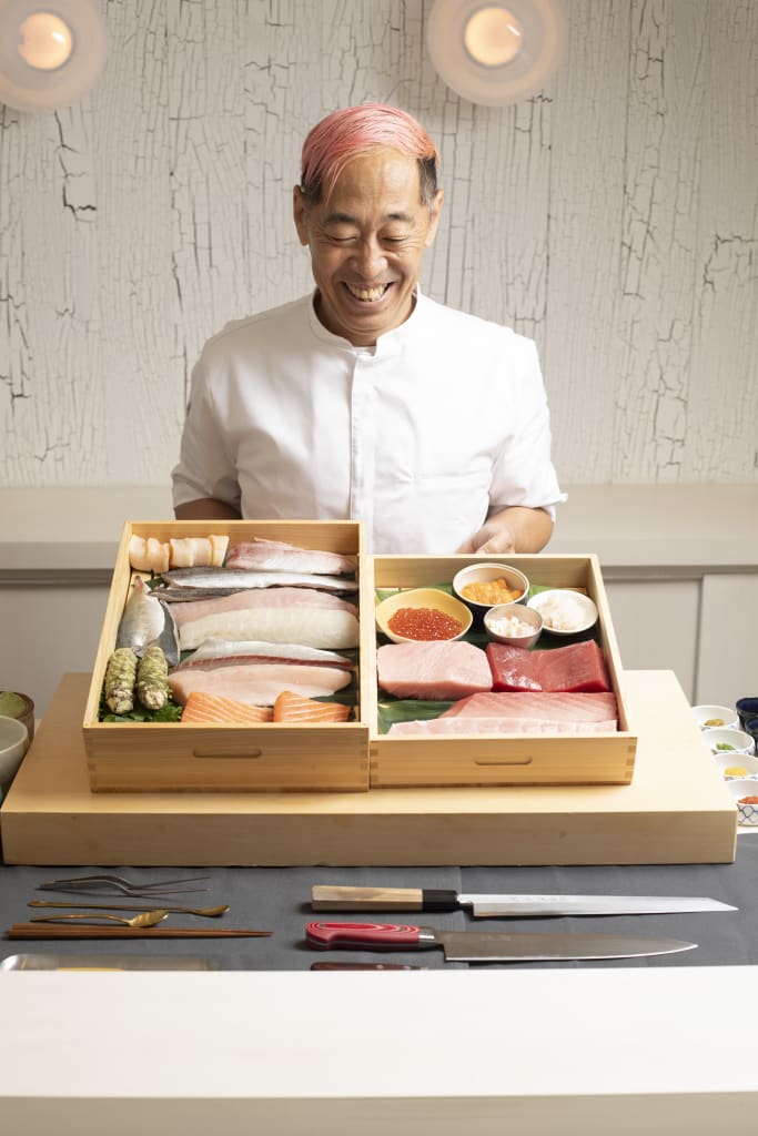 Atlanta Grows Talent, and Umi Is Taking It to New York 1 A smiling chef with pink hair stands behind a beautifully arranged sashimi platter, ready to prepare a meal in Atlanta, Georgia.