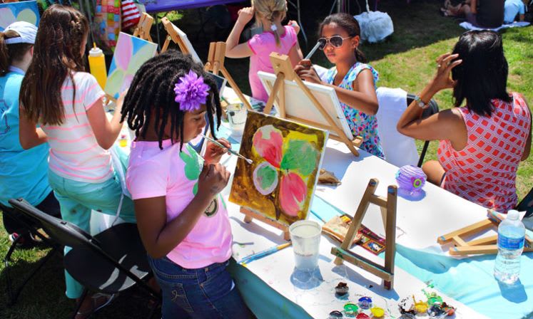 Entertainment Ideas 6 A group of young girls are painting at an outdoor art class, surrounded by colorful supplies in Atlanta, Georgia.