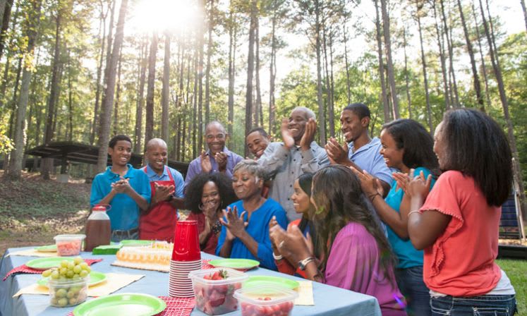 Entertainment Ideas 1 A diverse group of people celebrates a birthday in a forest setting in Atlanta, Georgia.