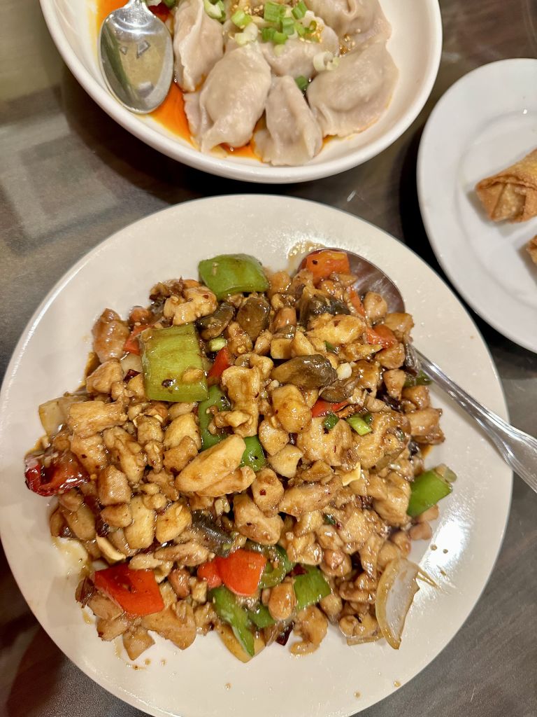 Where to Dine with a Large Group at Atlanta’s Michelin Guide Restaurants 15 A plate of stir-fried chicken with vegetables and dumplings on the side in Atlanta, Georgia.