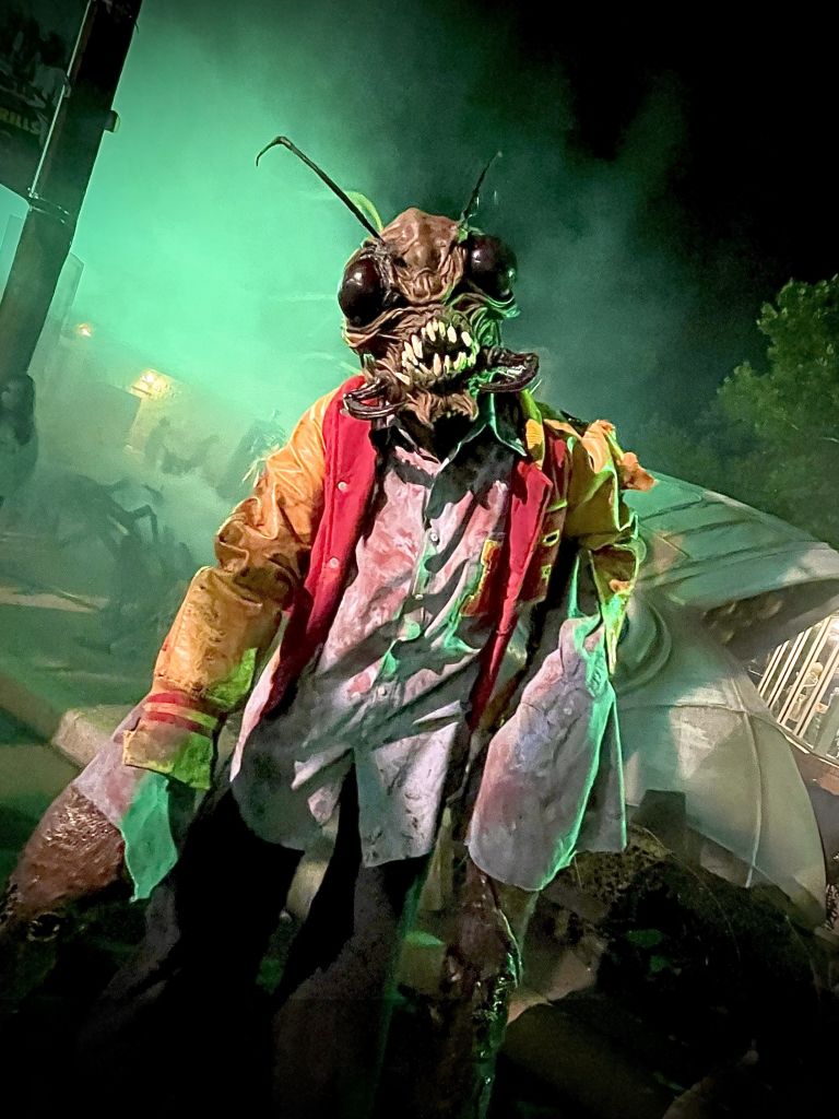 Cool Things To Do in October in Atlanta 1 A monstrous creature with a humanoid body and insect-like features stands amidst a smoky, eerie environment in Atlanta, Georgia.