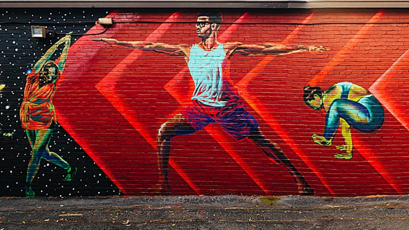 Cool, Funky Neighborhood: East Atlanta Village 3 A mural depicts three people in dynamic yoga poses against a red background in Atlanta, Georgia.