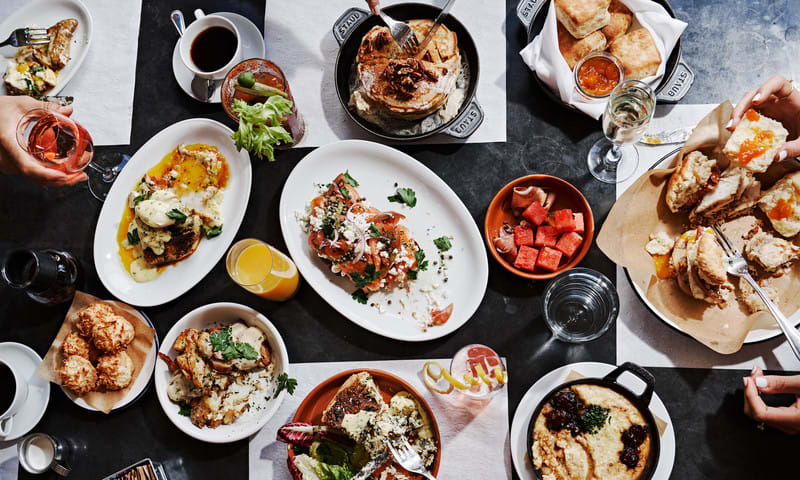 Shake It Up: Discover Atlanta’s Craft Cocktail Scene 1 A variety of breakfast and brunch dishes spread across a table, including eggs, pancakes, pastries, and fruit in Atlanta, Georgia.