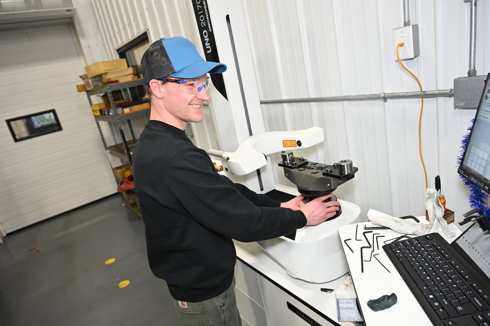 An A to Z Machine employee quality checking a custom made part sitting on a table