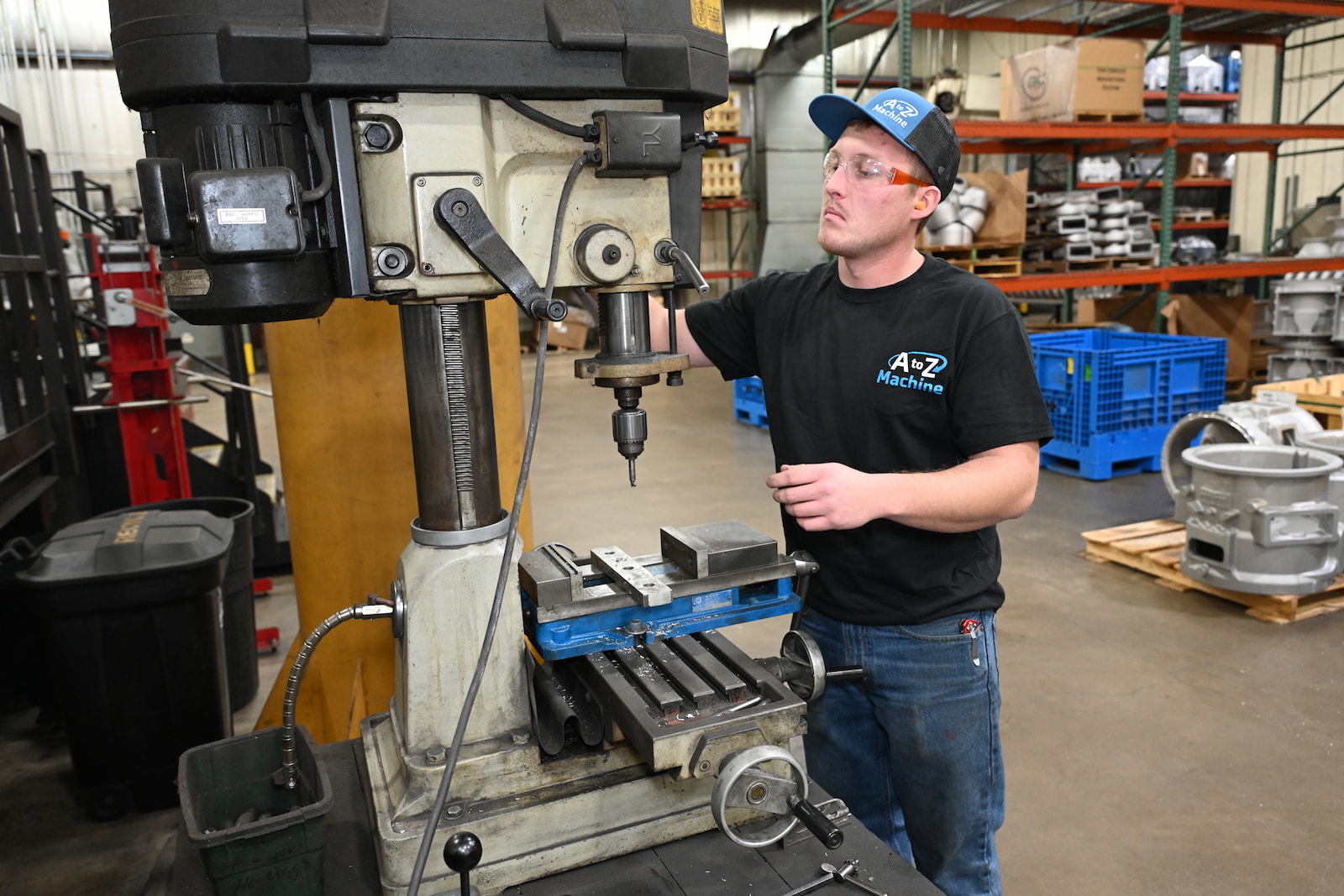An A to Z Machine employee quality checking a custom made part sitting on a table