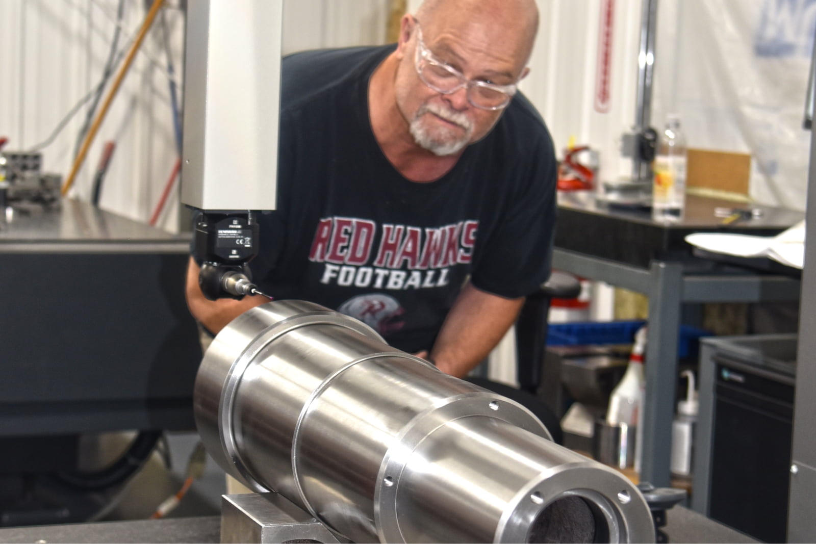 An A to Z Machine employee quality checking a custom made part sitting on a table
