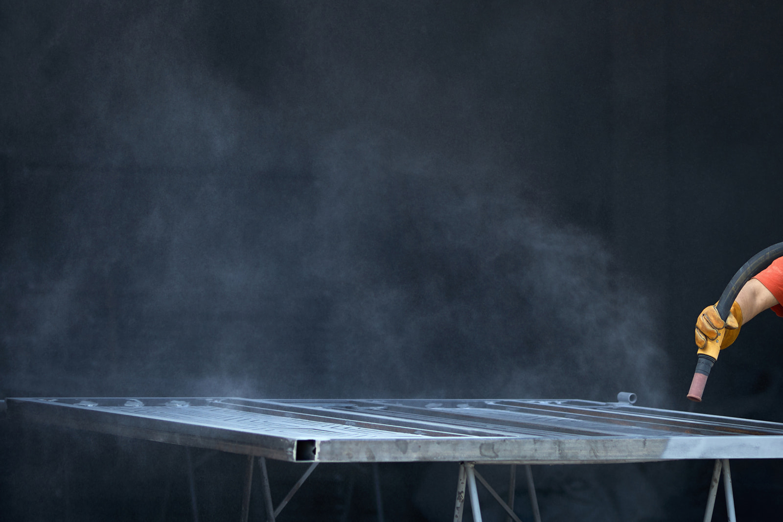 Industrial sandblasting process cleaning metal fabrication components in Appleton, WI.