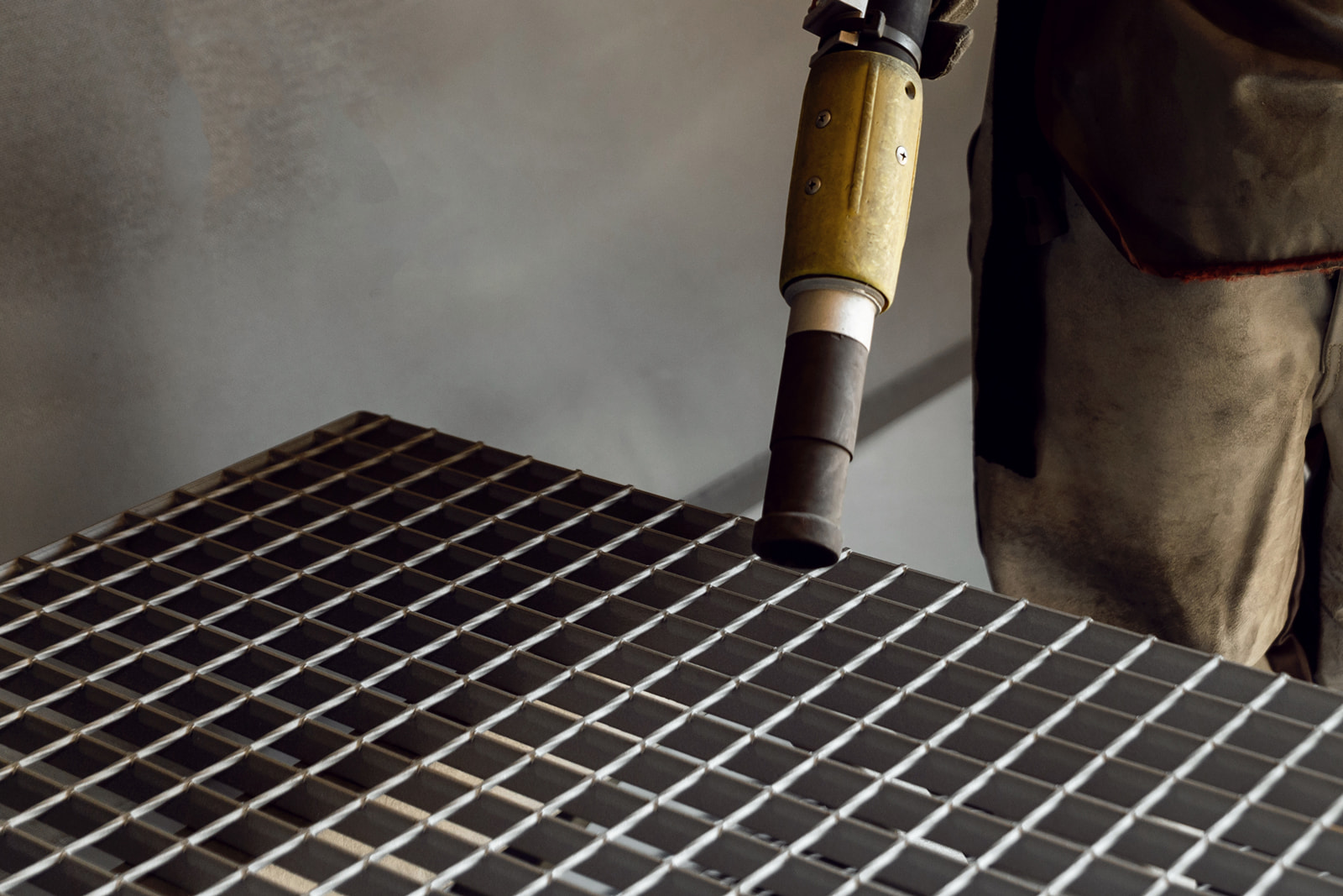 Industrial sandblasting equipment cleaning steel grating for metal finishing in Appleton, WI.