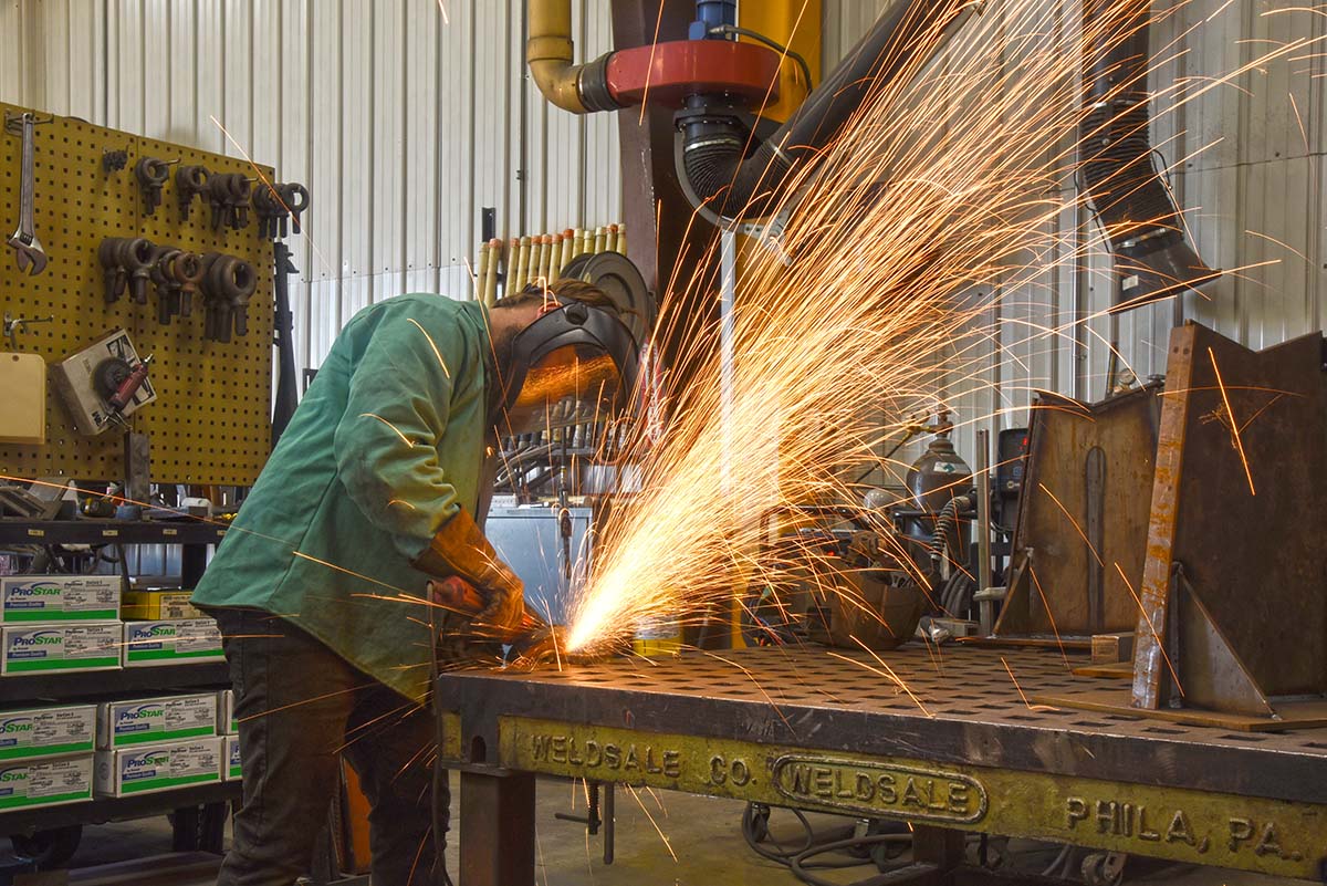 Sparks flying as employee uses a grinder on metal