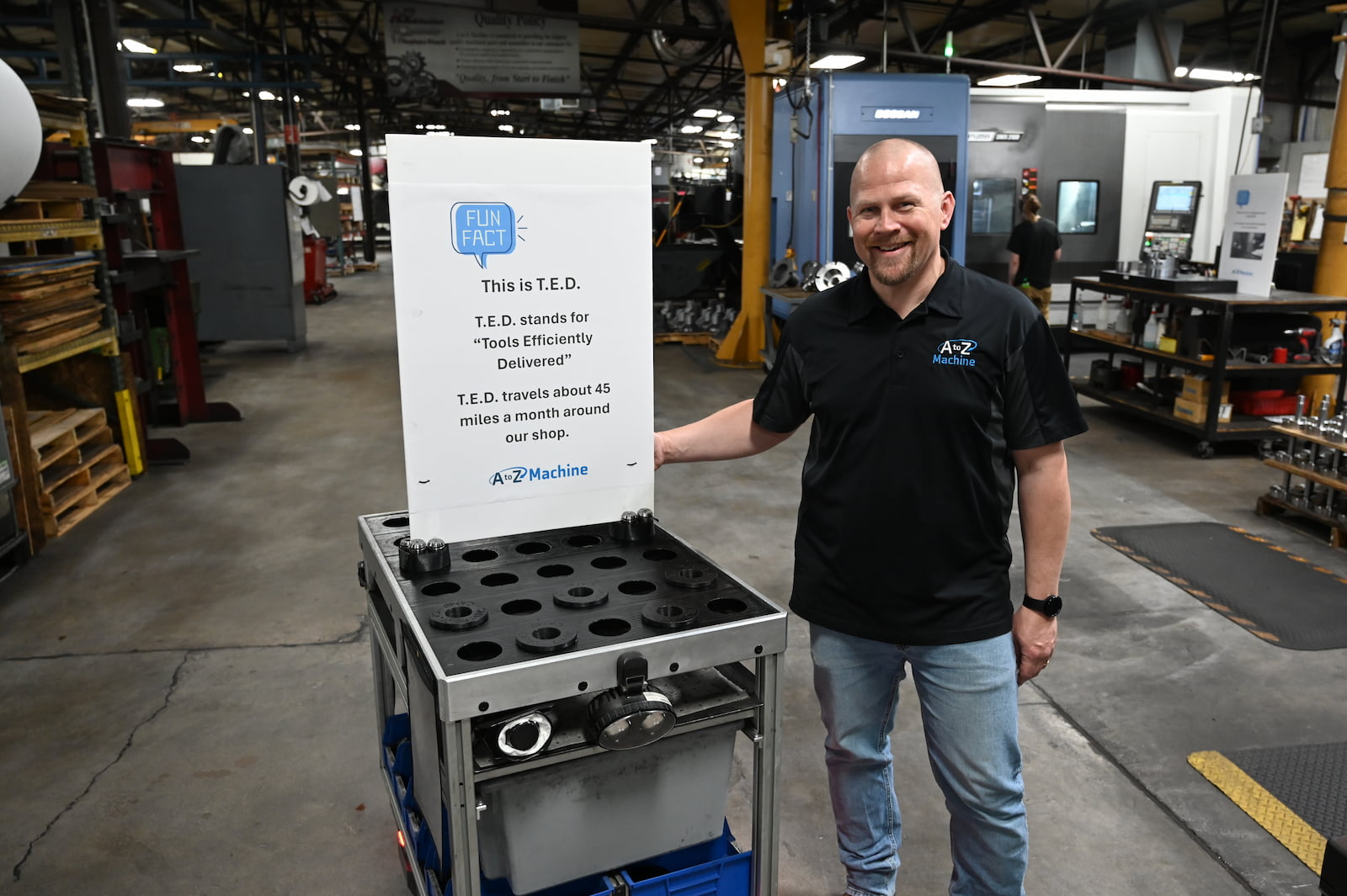An A to Z Machine employee quality checking a custom made part sitting on a table
