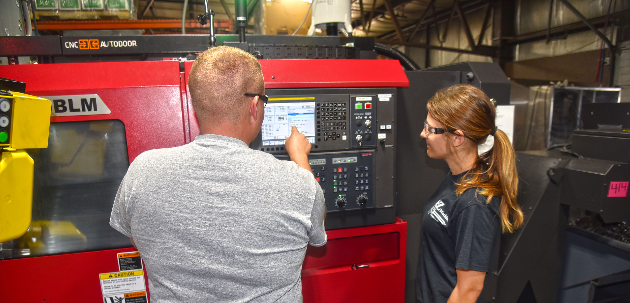 Two A to Z Machine employees looking at screen on a CNC Machine