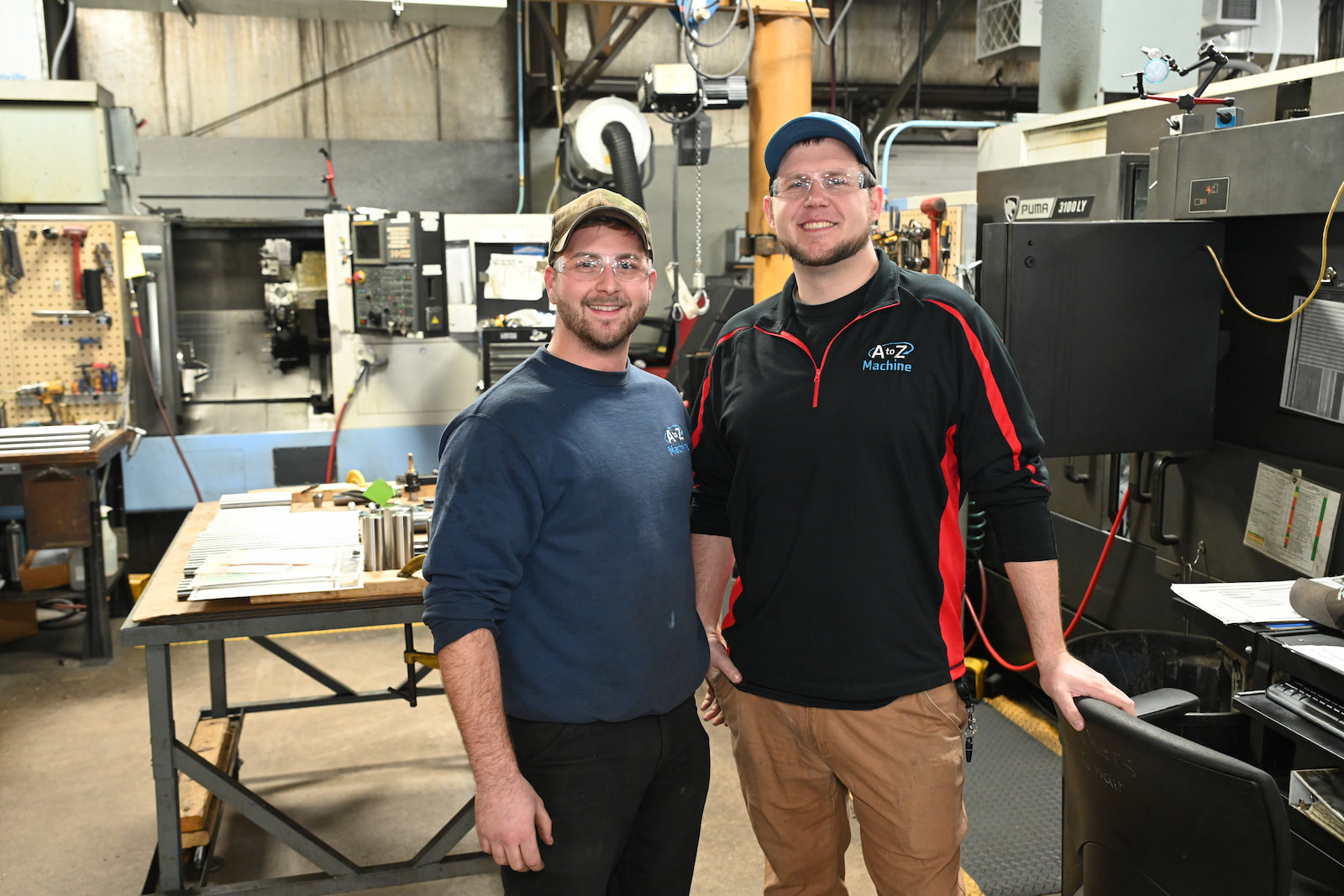 An A to Z Machine employee quality checking a custom made part sitting on a table