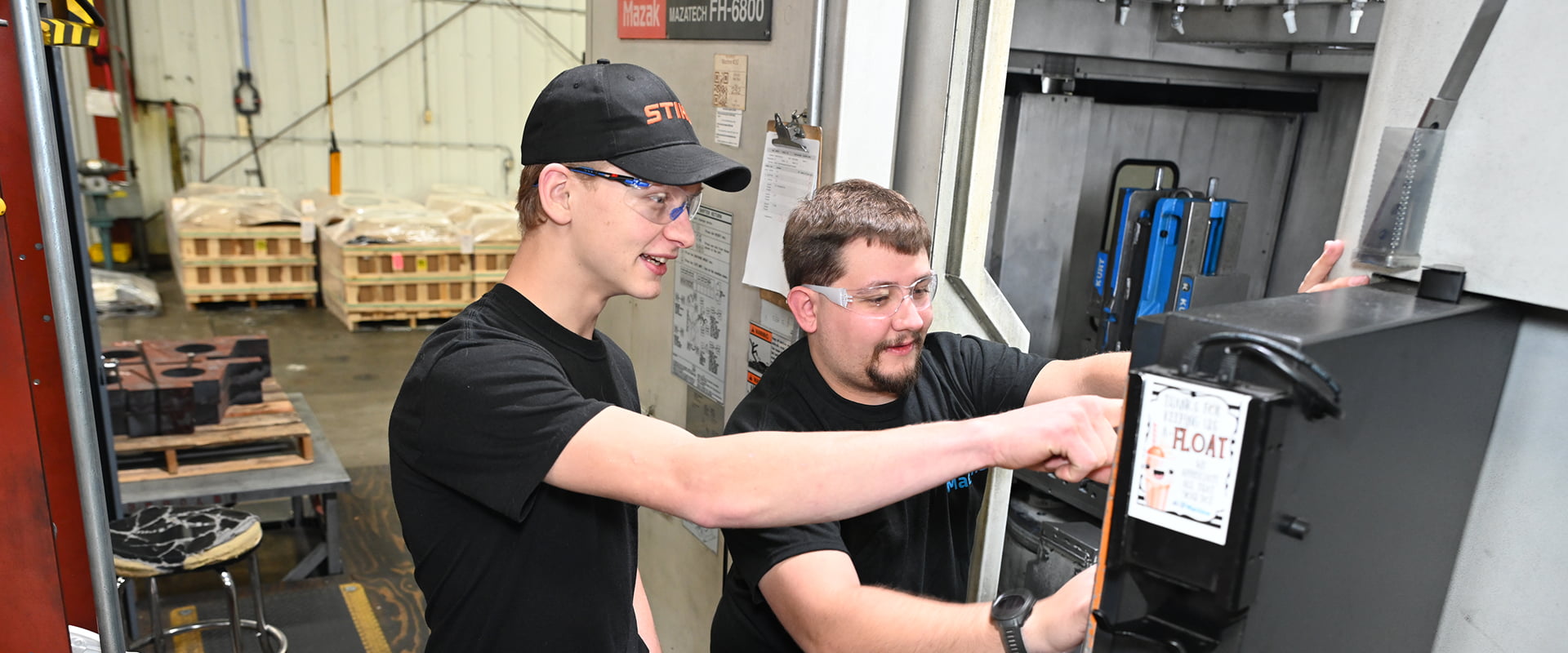 Two A to Z Machine employees looking at screen on a CNC Machine