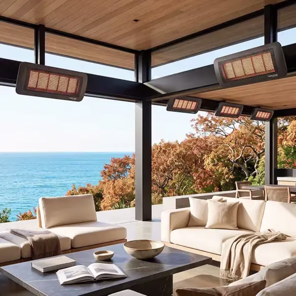 Multiple glowing patio heaters mounted beneath a covered coastal outdoor lounge.