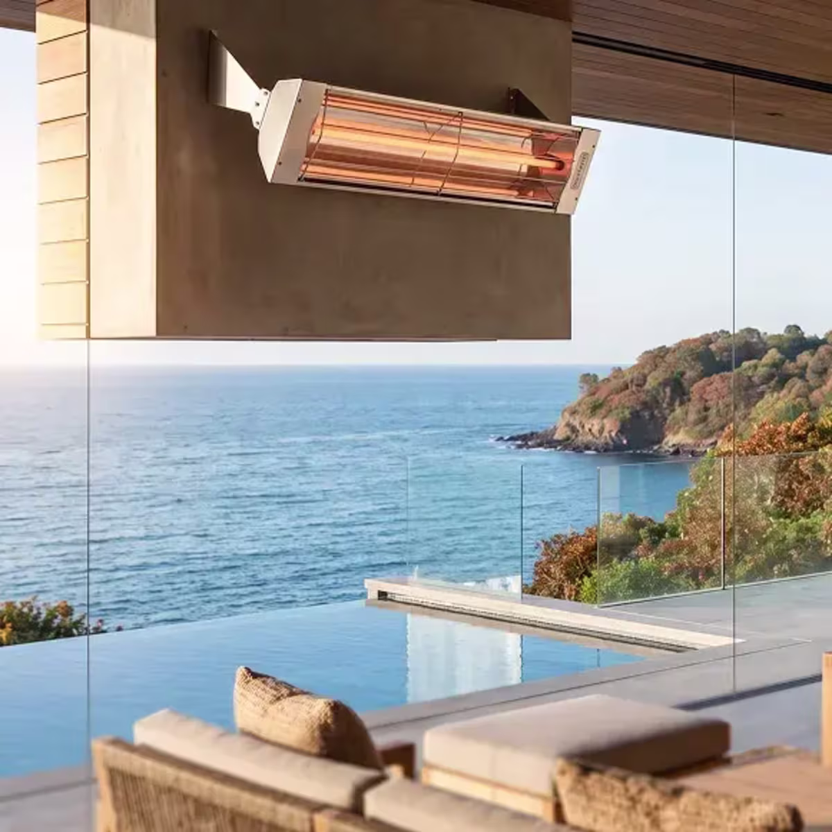 Wall-mounted patio heater above an outdoor seating area overlooking an infinity pool and ocean.