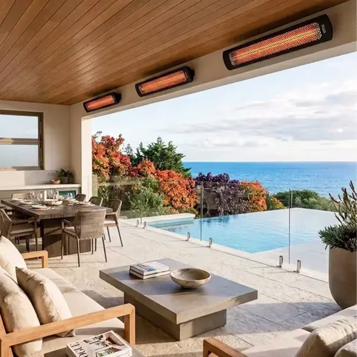 Three wall-mounted patio heaters above a covered dining and lounge area beside an infinity pool.