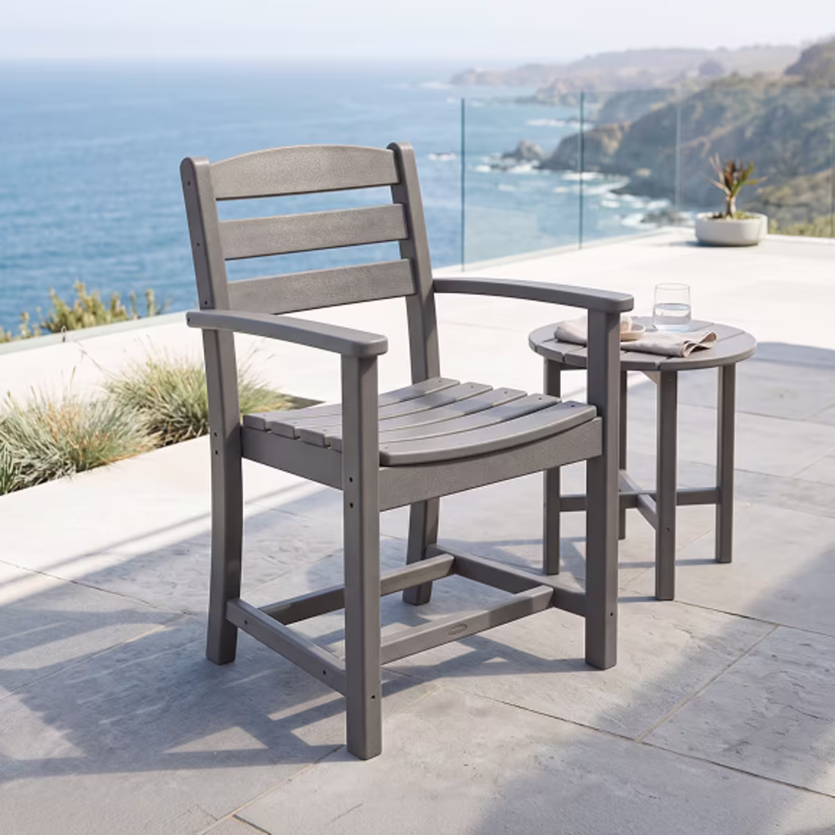 Gray outdoor armchair beside small table.