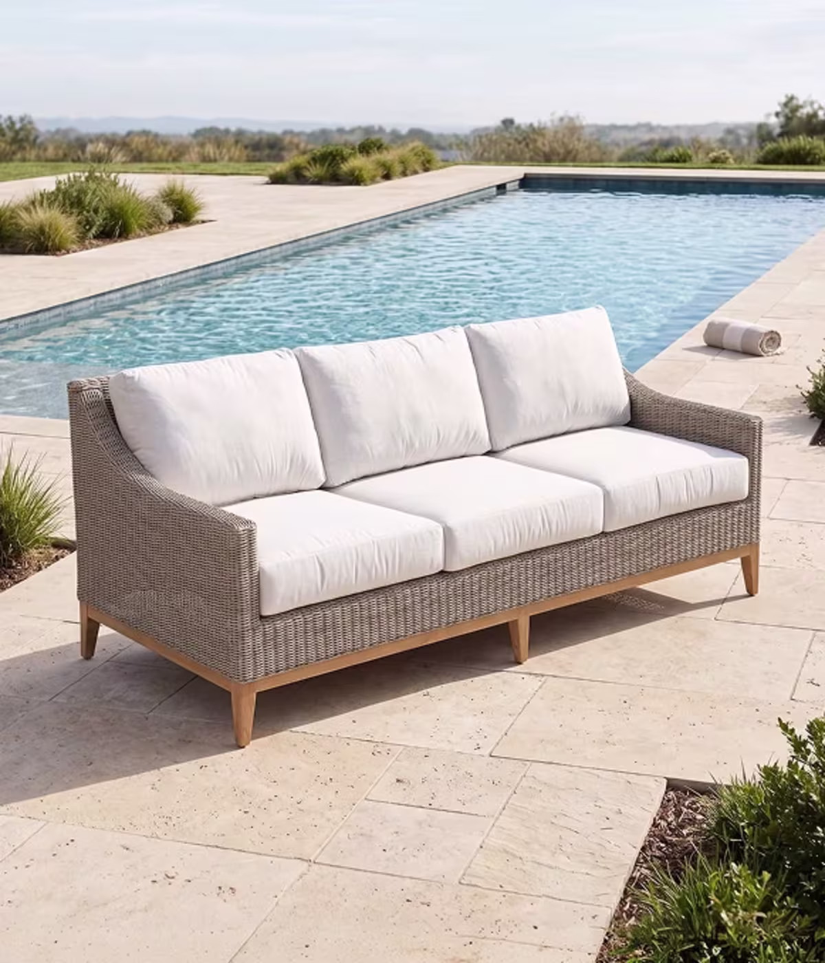 Woven wicker sofa beside swimming pool.
