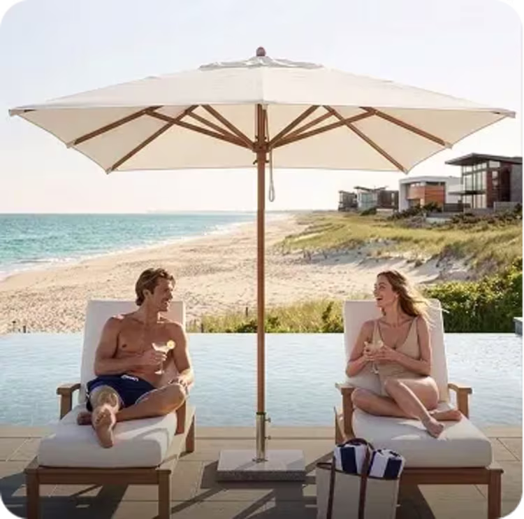 Couple lounging under seaside patio umbrella.