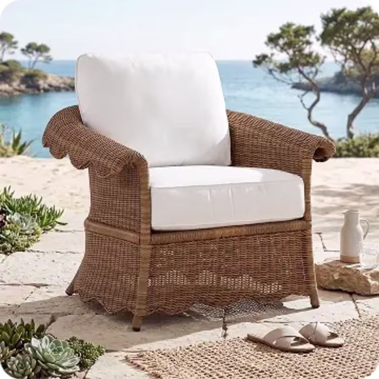 Wicker armchair with white cushions.