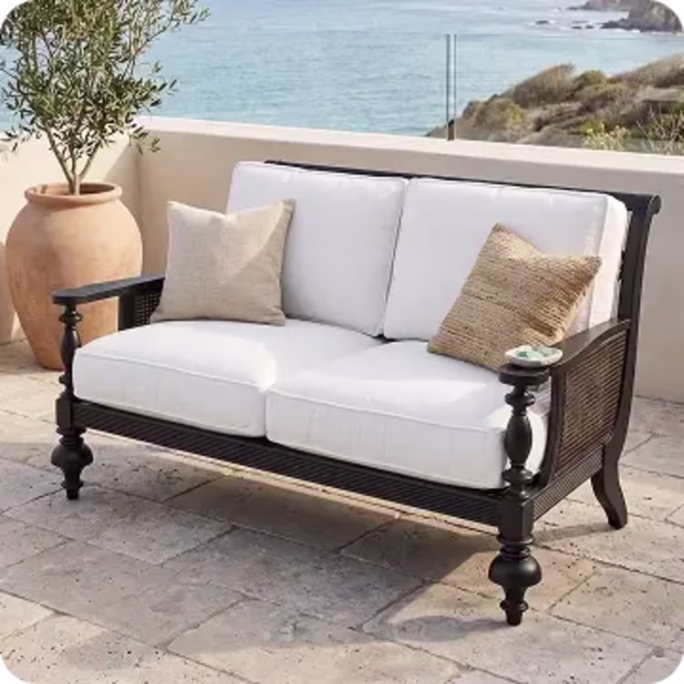 Black wooden loveseat with cushions.
