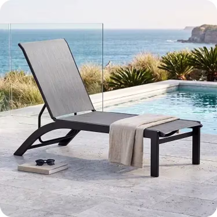 Poolside grey outdoor chaise lounge chair.