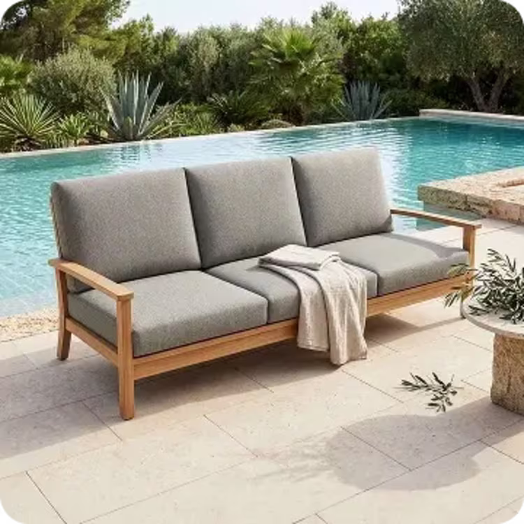 Cushioned wooden outdoor poolside sofa.