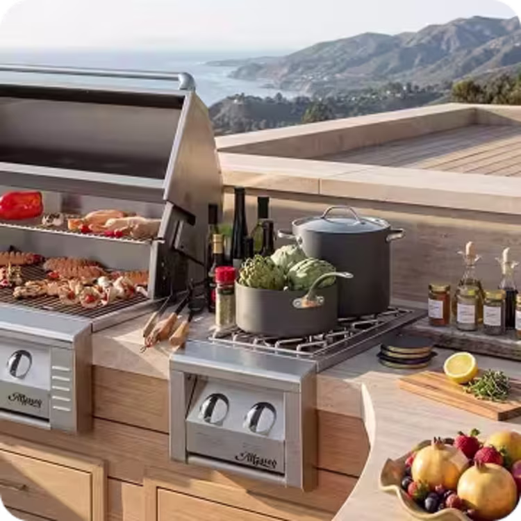 Contemporary outdoor kitchen with built-in grill, side burner, and food preparation area overlooking the ocean.