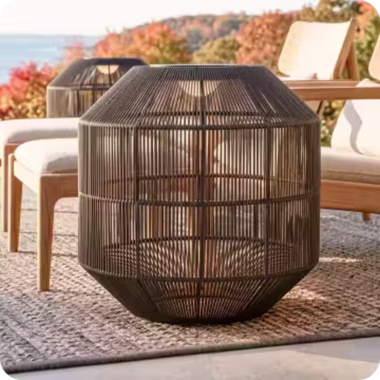 Black woven outdoor lantern beside cushioned patio furniture.