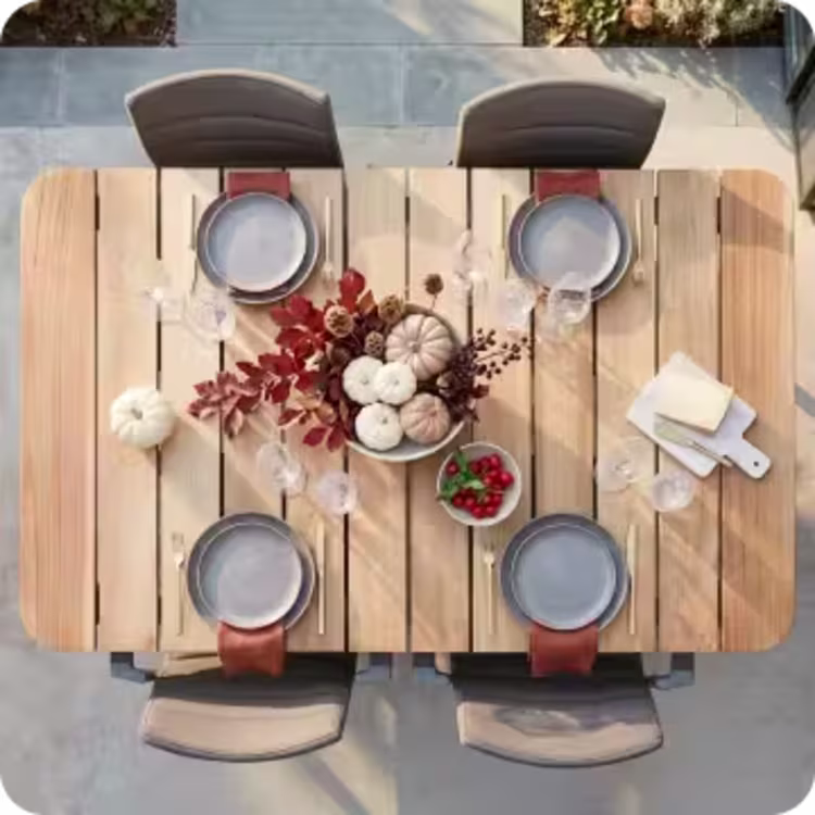 Overhead view of an outdoor dining table set for four with pumpkins and autumn decor.