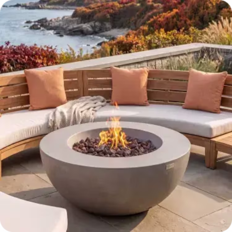 Round fire pit surrounded by cushioned seating on a coastal fall patio.