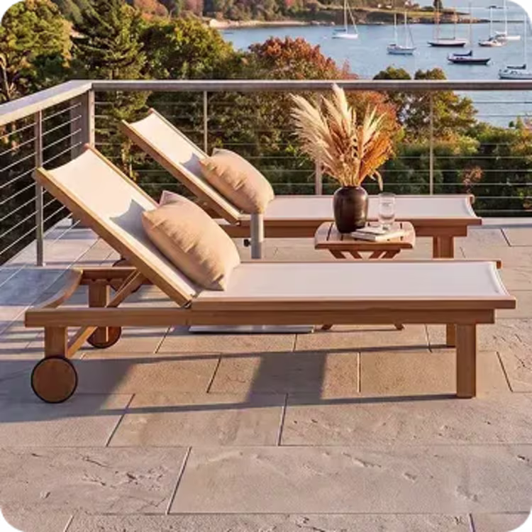 Teak chaise lounges on a waterfront patio with autumn harbor views.