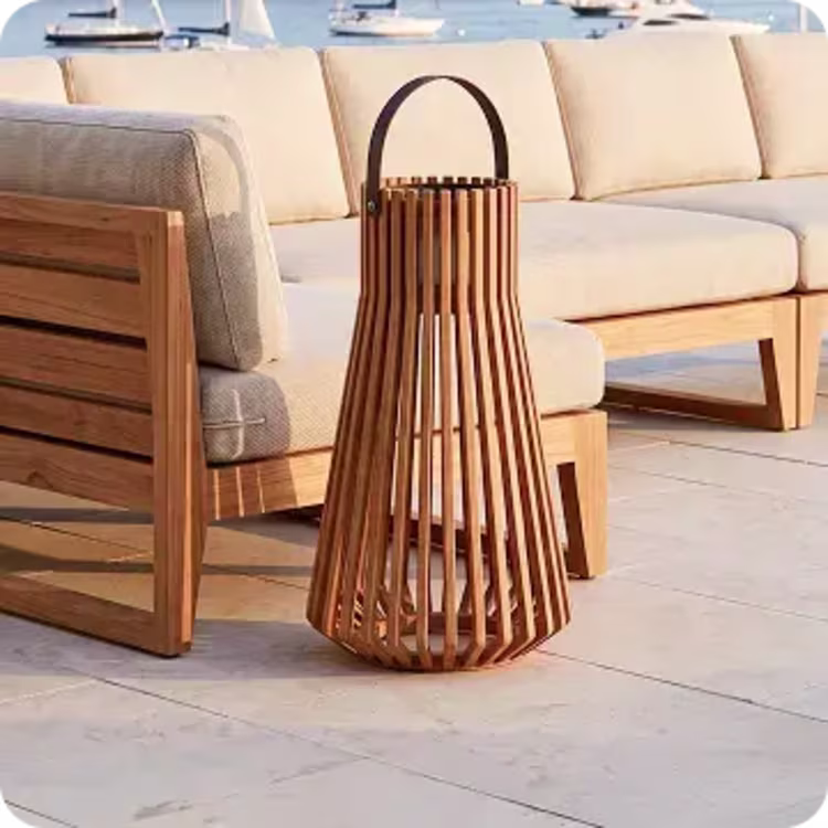 Wood lantern beside cushioned outdoor seating overlooking the water.