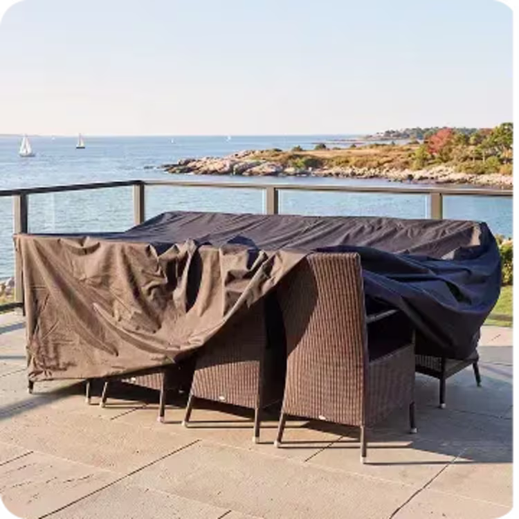 Covered outdoor dining set on a waterfront patio.