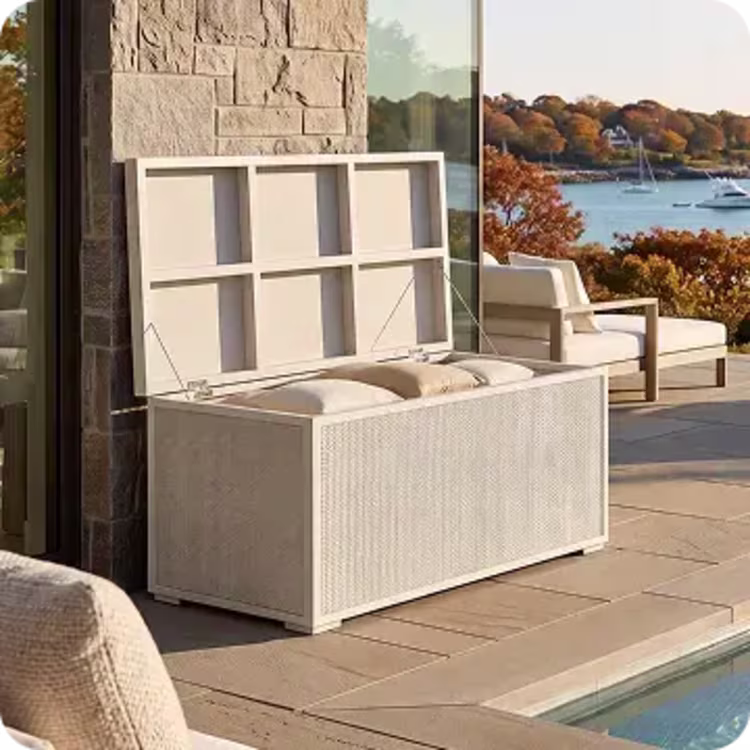 Open outdoor storage box on a waterfront patio with fall foliage.