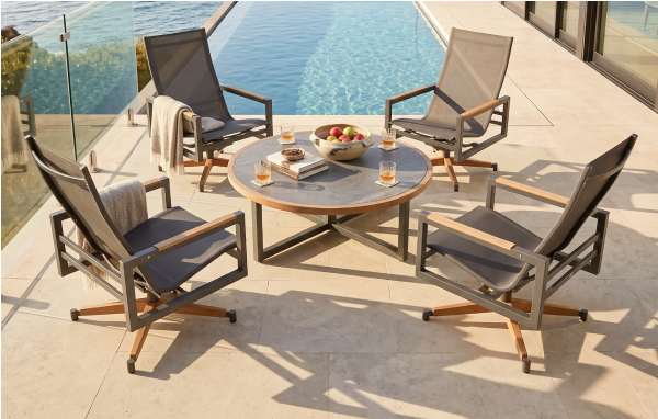 Four POVL Outdoor Qube swivel rocker lounge chairs around a poolside table