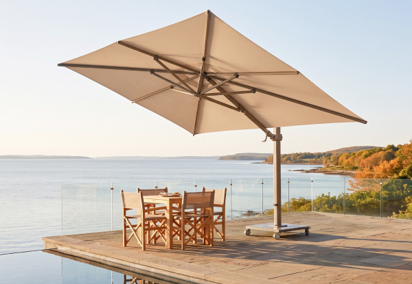 Jardinico Caractere cantilever umbrella shading a coastal dining area