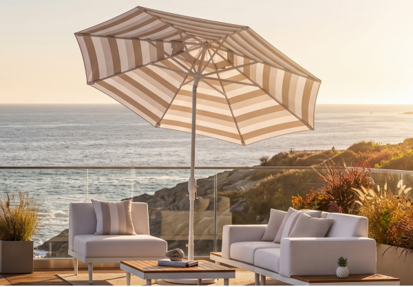 Striped Treasure Garden market umbrella shading a coastal lounge area