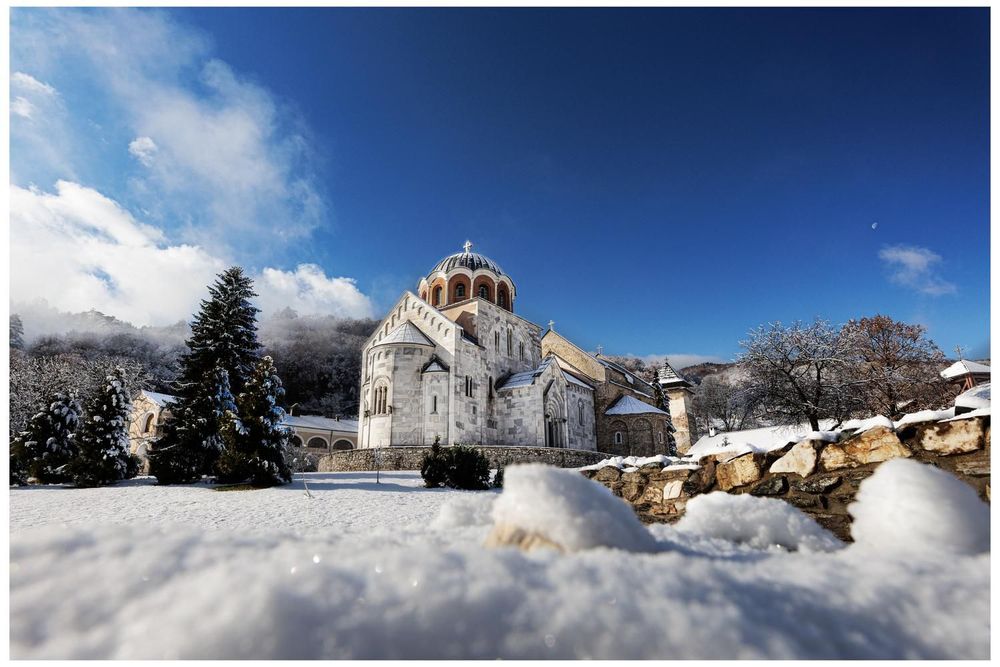 Studenica Monastery under snow, with the church surrounded by a winter landscape