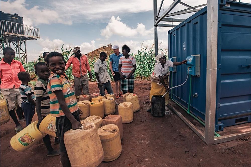 People with water containers gathered at a rural water supply point in Kenya.