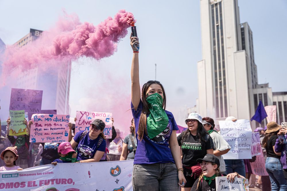 Women holding protest signs during a women's rights demonstration in Mexico City in March 2022.