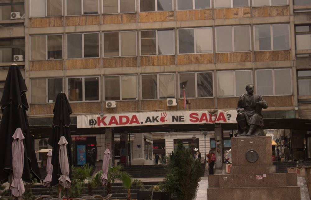 Jutarnji pogled na plato kod Rektorata Univerziteta u Beogradu, sa spomenikom, zatvorenim suncobranima i transparentom o blokadi na zgradi.