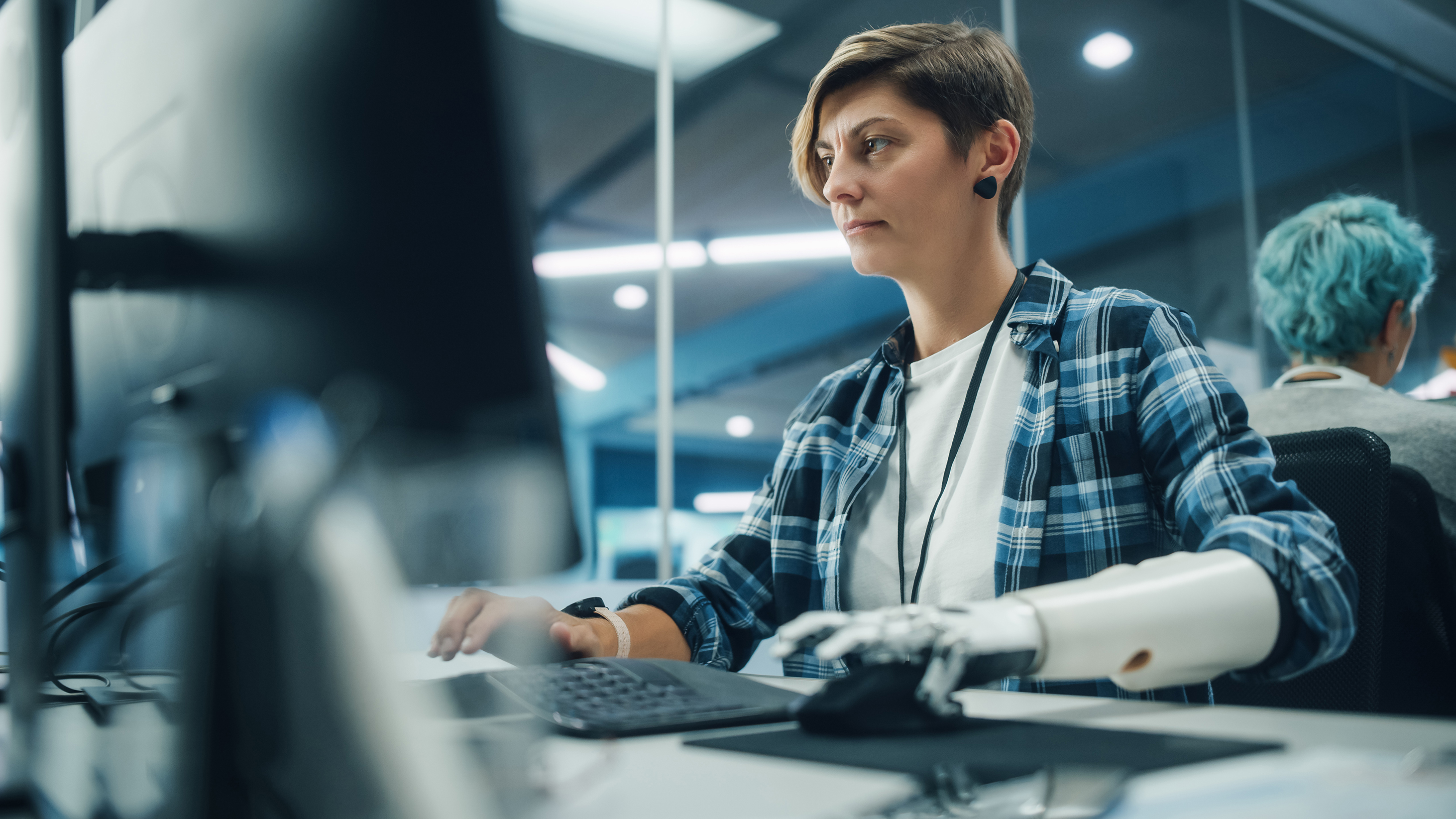 Woman with a prosthetic arm using a computer.