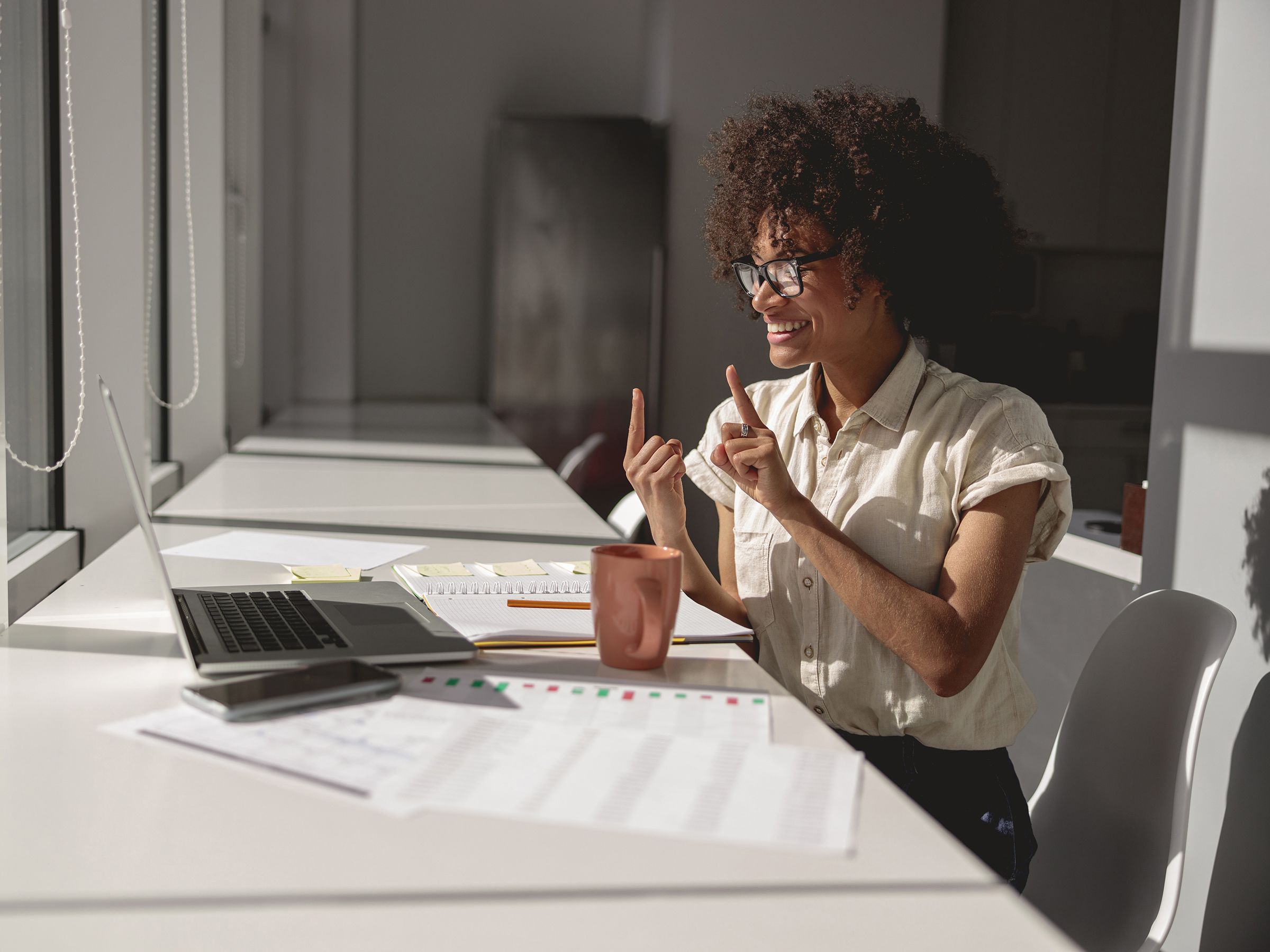 Woman signing toward a laptop.