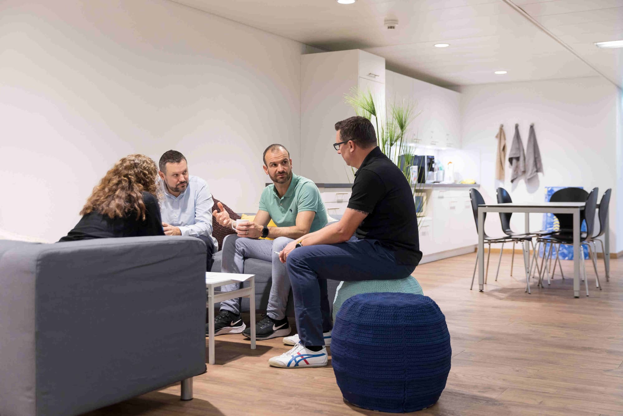 Vier Avega-Team im informellen Austausch in der Lounge-Ecke