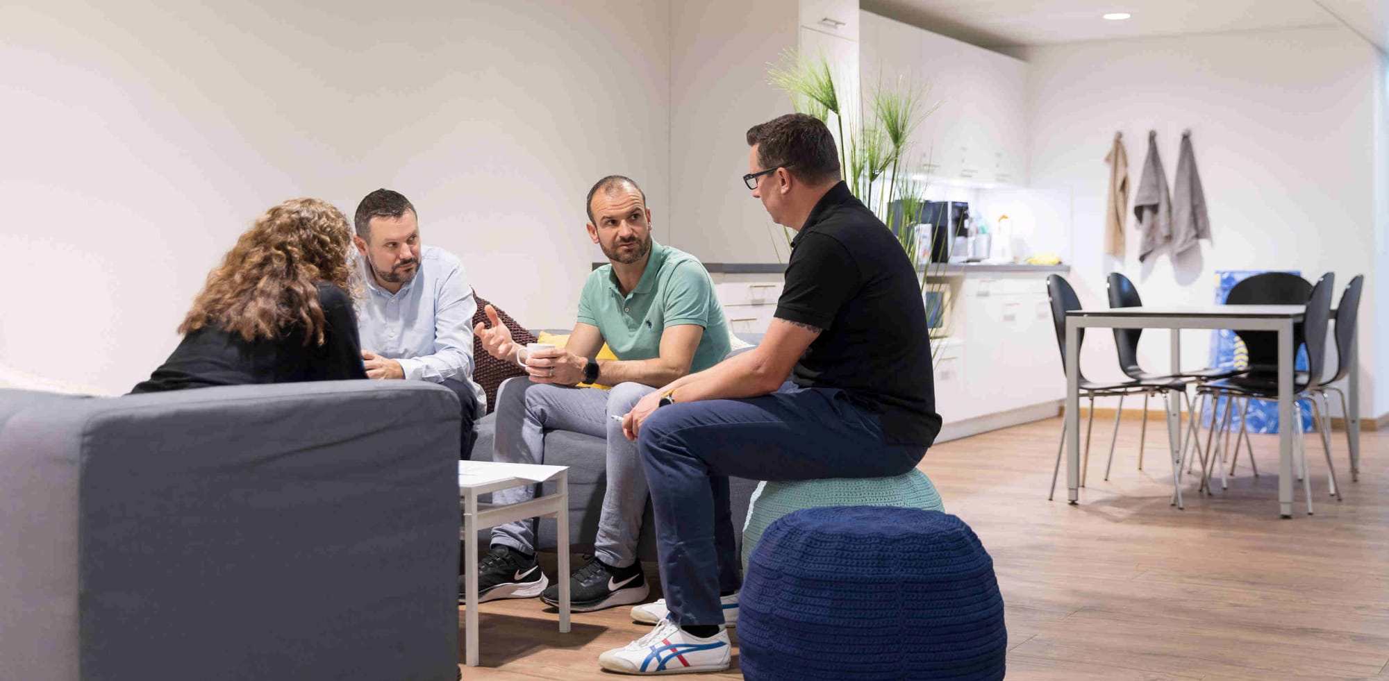 Vier Avega-Team im informellen Austausch in der Lounge-Ecke