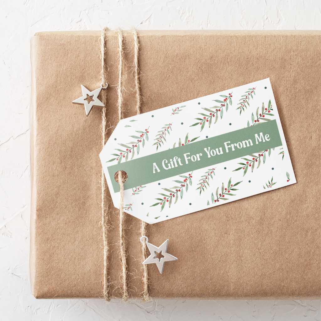 Wrapped kraft-paper gift box tied with twine and decorated with a printable holiday gift tag featuring a green banner that reads “A Gift For You From Me.”