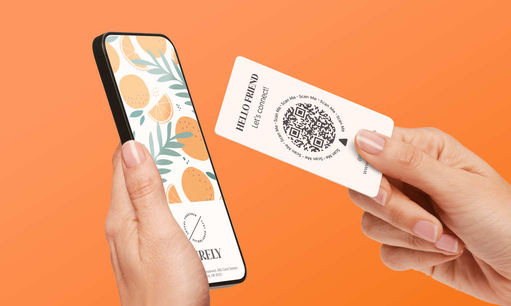 Person holding a business card with a QR code next to a smartphone, illustrating how physical business cards connect to digital content.